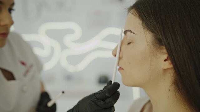 Side view of eyebrow microblading procedure in progress