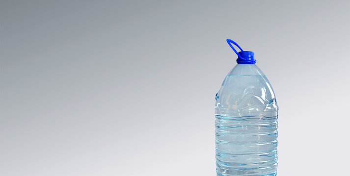 Big plastic bottle with drinking water, isolated on grey backdrop. Transparent 5l bottle, full, blue cap. Clean water supply concept. Horizontal studio shot