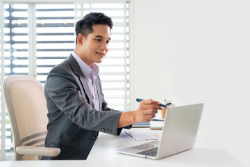 Fototapeta premium Asian manager businessman specialist doing paperwork analysing. Young business man working reading financial contract document in office workplace.