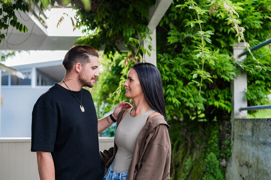 Couple conversing and standing close to each other outside their home