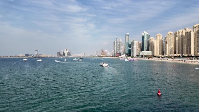 High angle view of Jumeirah Beach Residence (JBR) coastline and turquoise waters with yachts and luxury skyscrapers