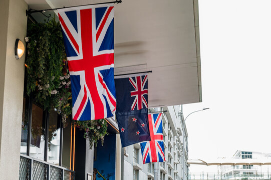 Flags are hanging from a building with a floral arrangement, showcasing a blend of national symbols