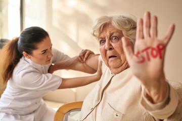 Obraz premium Terrified Senior Woman Protests Physical Abuse from Female Caregiver