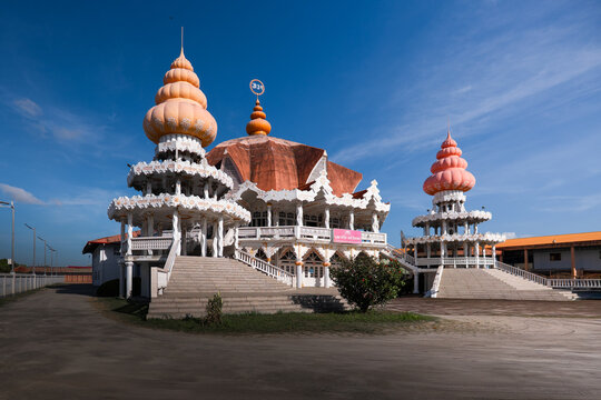 View of the ornate Arya Dewaker Hindu temple with its distinctive orange domes and white pillars under a clear blue sky in Paramaribo, Paramaribo District, Suriname.