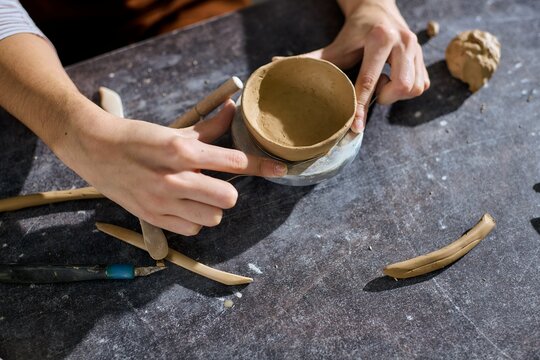 Creative moments in a pottery studio with a talented young woman shaping clay