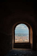 Fototapeta premium View of Naples cityscape through an ancient arched window from a historic building