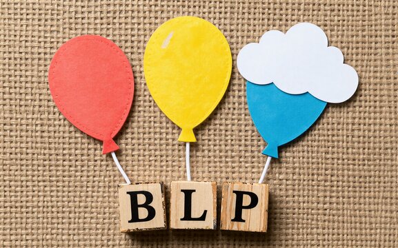 Colorful balloons float above wooden blocks spelling BLP on a