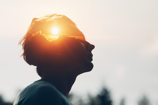 Sun rising above the clouds inside the silhouette of a male head. The way of thinking and psychology of successful man. Positive mindset of modern businessman.