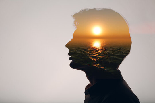 Sun rising above the ocean inside the silhouette of a male head. Way of thinking and psychology and mindset of successful young man.