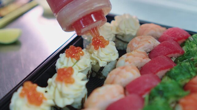 Sushi set. Japanese food. A sushi chef decorates and decorates a sushi set with various toppings. Sushi preparation.