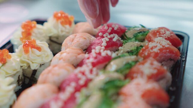 Sushi set. Japanese food. A sushi chef decorates and decorates a sushi set with various toppings. Sushi preparation.