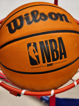 Prague, Czech Republic &ndash; March 31, 2026: Wilson NBA DRV basketball caught in hoop net with visible NBA logo and Wilson branding, close-up of official league ball on retail display in sporting goods