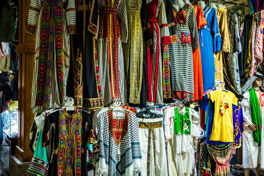 Colorful traditional dresses hanging in market stall