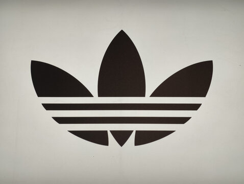 Prague, Czech Republic &ndash; March 31, 2026: Adidas Originals trefoil logo illuminated on closed metal shutter at retail store exterior, close-up of brand signage