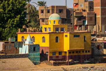 Colorful riverside building with dome and village houses © Emad Aljumah