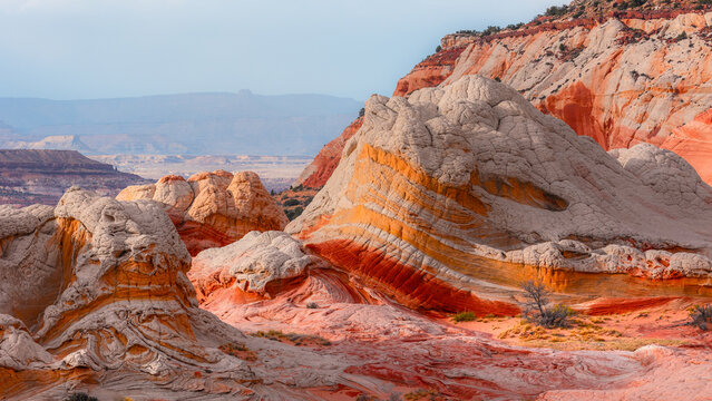 View of White Pocket featuring unique white and orange sandstone rock formations under a clear sky Coconino County, Arizona, United States.