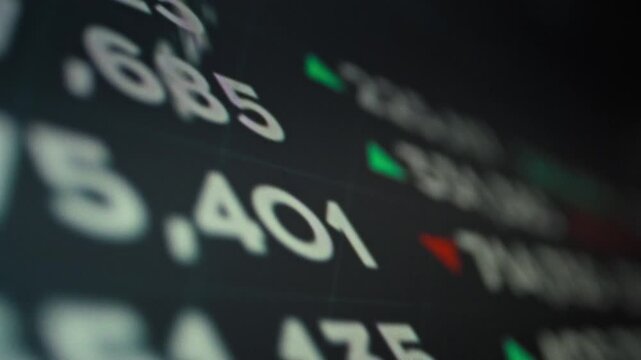 Monitor screen flickers with dynamic stock market information, displaying real-time quotes, changing exchange rates, and indices. The vibrant display showcases current market trends and trading data