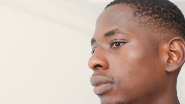 Black man lowangle looking upward, highkey interior with minimalist ceiling, determined jawline and confident expression, cinematic portrait of a black leader envisioning future