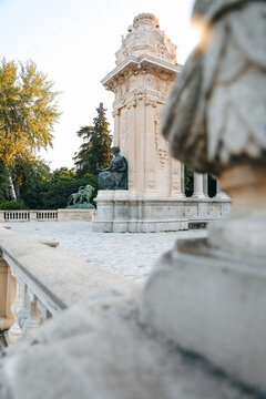 View of the Monument to Alfonso XII featuring stone sculptures and lush green trees in Retiro Park Madrid, Community of Madrid, Spain.