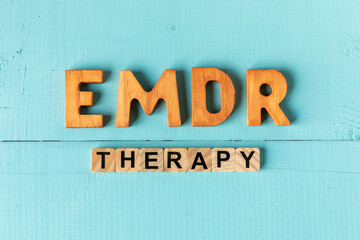 Fototapeta premium Words EMDR Therapy on blue painted boards. Eye Movement Desensitization and Reprocessing therapy concept.
