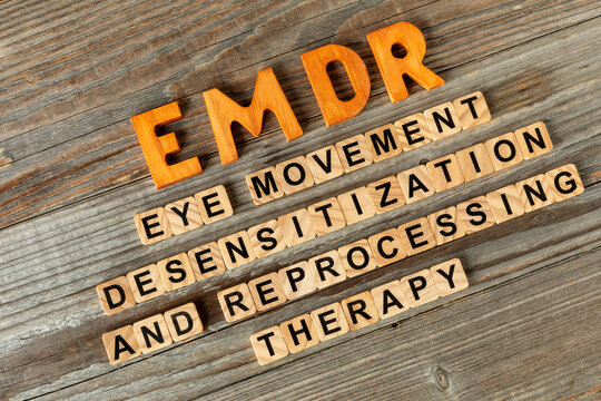 The acronym EMDR and its individual words. Wooden letters and letters painted on wooden blocks. Eye Movement Desensitization and Reprocessing psychotherapy treatment concept.
