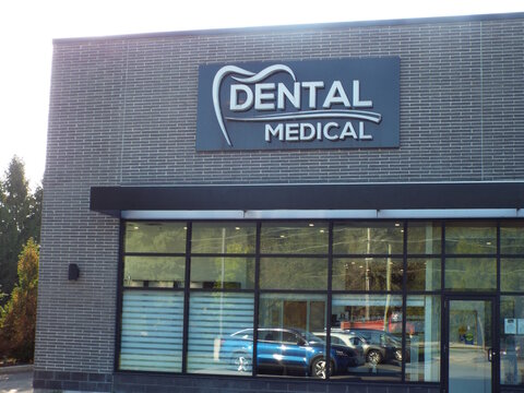 Gloucester, Ontario, Canada &ndash; July 24, 2025: The "Dental Medical" storefront features a black sign with a tooth logo, grey brick exterior, and large reflective glass windows at 665 River Rd #103.