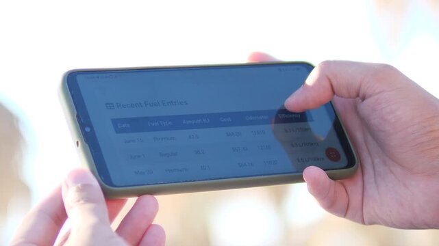 Close-up of a person using a car management app to track fuel costs and efficiency. Professional UI showing budget and consumption data. Great for personal finance, automotive tech, and eco-driving