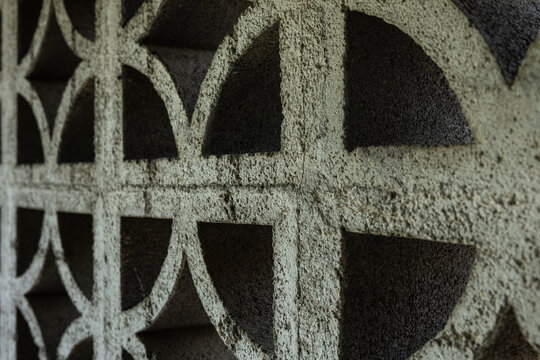 Close up image of old warn and cracked decretive cinder block wall textured background.