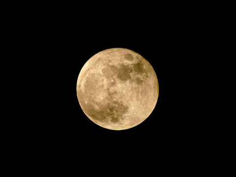 Full moon with visible craters and shadows, moonlight, circle moon phase on black background. Small cloud in front of super moon.