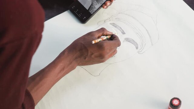 Artist sketching demonstration. Drawing with shading and contrast. Practicing tonal variations on textured paper. Closeup of artist refining pencil shading techniques with reference tools