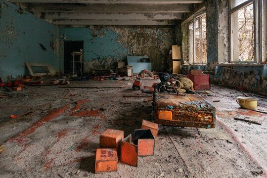 View of an abandoned kindergarten room with peeling paint, scattered toys, and debris on the floor in Pryp'yat', Kyiv Oblast, Ukraine.
