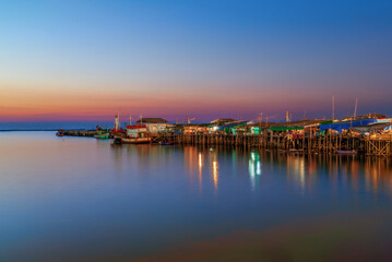 Fototapeta premium Traditional wooden pier with fishing boats at sunset in Ang Sila Chonburi Thailand