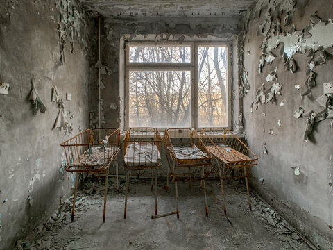 View of abandoned hospital room with rusty metal baby cribs and peeling paint on the walls Pryp'yat', Kyiv Oblast, Ukraine.