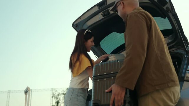 Taxi driver helping female passenger lift luggage into car. Friendly service, urban transportation. Travel assistance and modern city lifestyle concept.
