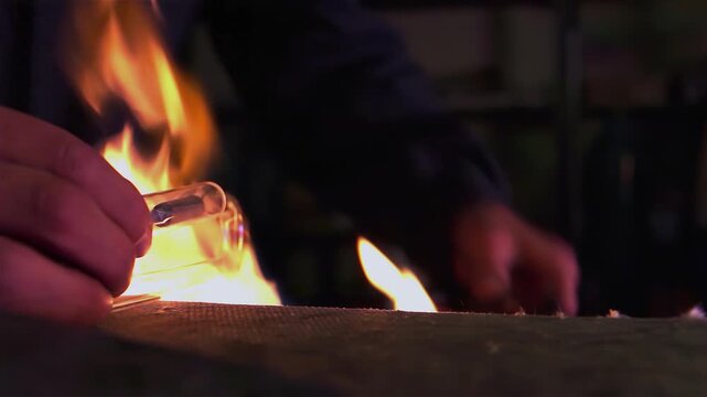 Artisan Heating Neon Glass with Gas Burner Flame in Dark Studio, Close Up - 4K