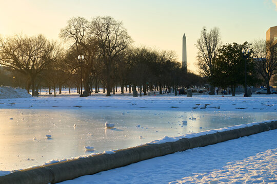 Capitol Reflecting Pool frozen in winter with Washington Monument obelisk at the background