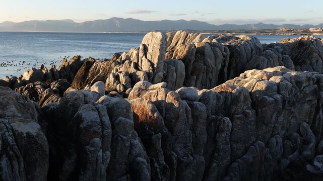 Rocky coastline, DeKelders,  South  Africa, overlooking Walker Bay Nature Reserve and Klein Mountains