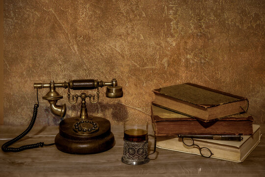 Vintage still life with rotary phone and antique books.