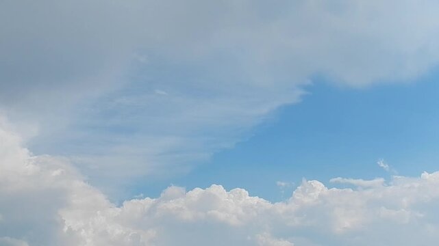 Blue sky with Cumulus and Cirrostratus clouds and flying butterflies in summer weather - natural sky background. Topics: cloudscape, meteorology, nature, natural environment, air space, cloud types