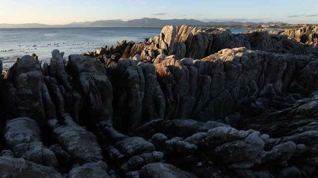 Rocky coastline, DeKelders,  South  Africa, overlooking Walker Bay Nature Reserve and Klein Mountains
