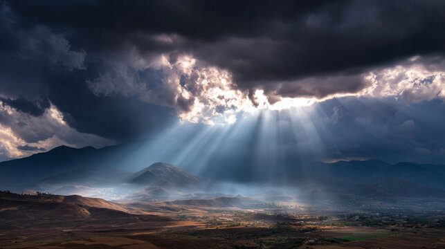 Majestic sunrays piercing through clouds over mountains.