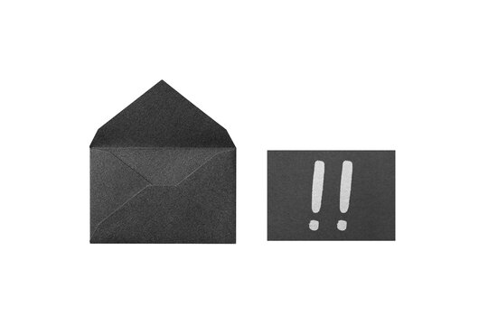 Seen from above: a opened black glitter envelope next to a message card with a hand-drawn white exclamation mark