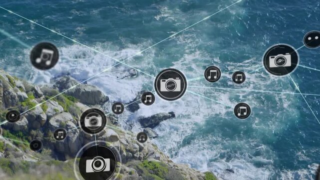 Animation of network of digital icons against aerial view of sea waves hitting the rocks
