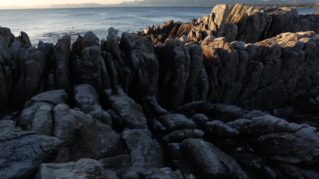 Rocky coastline, DeKelders,  South  Africa, overlooking Walker Bay Nature Reserve and Klein Mountains