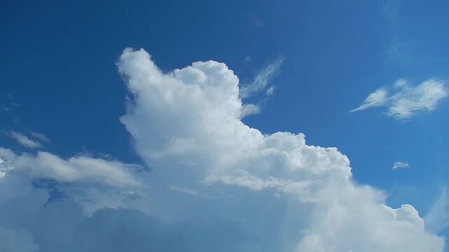 Blue sunny sky with Cumulus clouds and flying butterflies in summer weather - natural sky background. Topics: cloudscape, meteorology, nature, natural environment, air space, cloud types, altitude