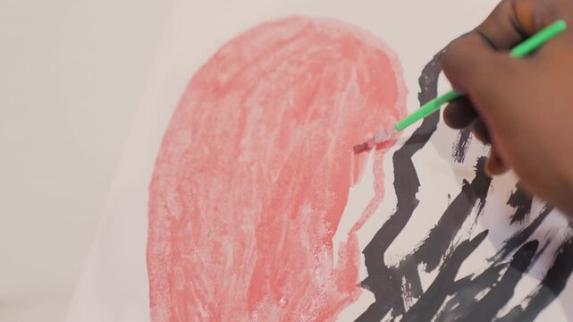 Final strokes on black painting heart, hand dips brush in water and refines red fill near bold black outline, warm studio light, finishing ritual with gentle motion, subtle glaze and texture smoothing