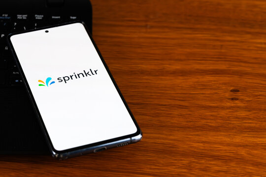 Punta Arenas, Chile &ndash; March 31, 2026: The Sprinklr logo displayed on a smartphone screen resting on a wooden desk next to a laptop keyboard