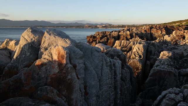 Rocky coastline, DeKelders,  South  Africa, overlooking Walker Bay Nature Reserve and Klein Mountains