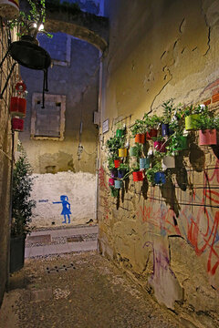 Night street scene in sassari with recycled flower pots.