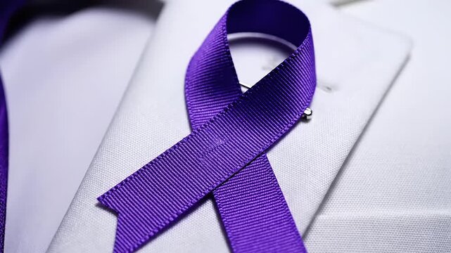 Purple ribbon on white suit jacket.